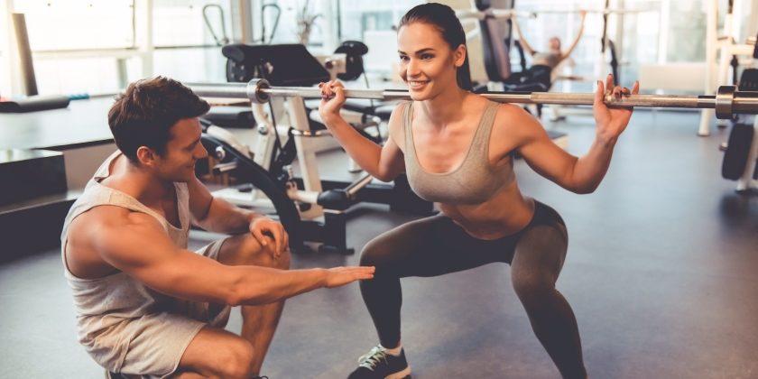 Frau macht unter Anleitung eines Personal Trainers Muskeltraining